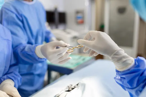 Surgical team passing instruments during a procedure in an operating theatre